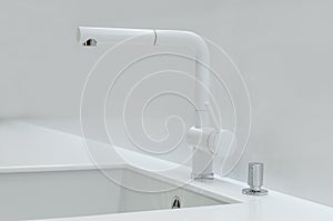 A new white kitchen sink made of artificial stone and a faucet. The concept of modern kitchen interior