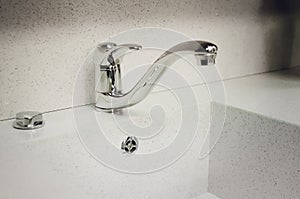 A new white kitchen sink made of artificial stone and a faucet. The concept of modern kitchen interior