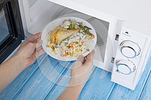 White microwave oven, on a blue wooden surface for heating food