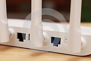 New white Wi-Fi router on wooden table, closeup