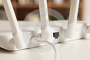 New Wi-Fi router on white table indoors, closeup