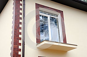 A new window in a new house. Unfinished balcony. Decorative plaster. Decorative tiles. Urban house or building, facade pattern. Ra
