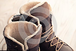 New winter shoes, brown boots with wood background. buying winter shoes