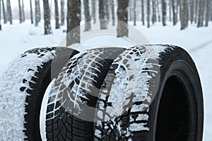 New winter tires covered with snow near forest
