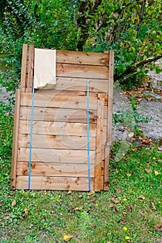 New wooden composter in wood kit ready to be mounted in home garden as compost recycler of vegetable and household waste bin