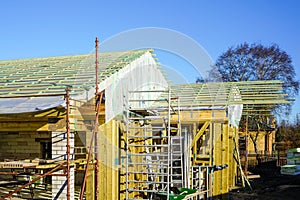 New wooden construction building in the construction process, roofing with waterproofing film photo