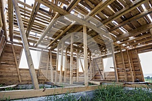 New wooden house under construction. Close-up of walls and ceiling frame with windows openings from inside. Ecological dream home
