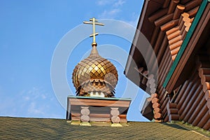 New wooden Orthodox church, dome with a cross and blue sky. Russia