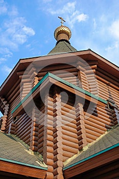 New wooden Orthodox church, dome with a cross and blue sky. Russia