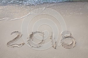 New Year 2018 is coming concept. wave coming to 2018 concept on the sand beach in the morning