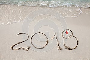 New Year 2018 is coming concept. wave coming to 2018 concept on the sand beach in the morning.