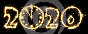 New Year 2020 with clock made by sparkler . Number 2020 and sign written sparkling sparklers . Isolated on a black background .