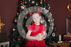 New Year 2020. Merry Christmas, happy holidays. Close-up portrait of a little girl with a candle. Little girl holds a candle in he