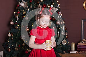 New Year 2020. Merry Christmas, happy holidays. Close-up portrait of a little girl with a candle. Little girl holds a candle in he