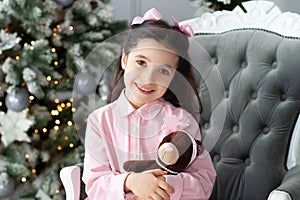 New Year 2020! Merry Christmas, happy holidays! Portrait of a little girl with bows on her head holding a gift of a teddy bear smi