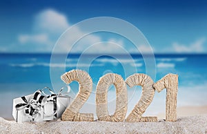 New Year 2021 on the beach. Snowman and Christmas gifts in sand