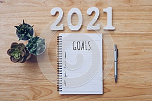 New year 2021 goals list. Office desk table with notebooks and pancil with pot plant