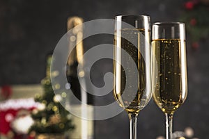 New year 2021 - two glasses of champagne on a dark background with bokeh from garlands