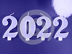 New year 2022 candle numbers on shiny purple background