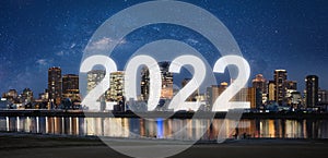 New Year 2022 in the city. Panoramic city at night with starry sky and happy new year 2022 celebration