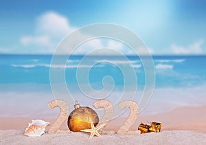 New Year 2022 on hot beach with seashells and starfish