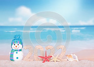 New year 2022 sign with snowman on beach background