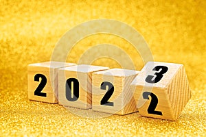 New Year 2022 to 2023, Numbers on wooden blocks, Merry Christmas and Happy New Year, Golden glitter background