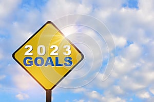New year 2023 goals on yellow sign on beautiful blue sky with fluffy cloud background