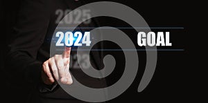 New year 2024 with goal. Businessman pointing to the numbers of the year to set goals for the coming year