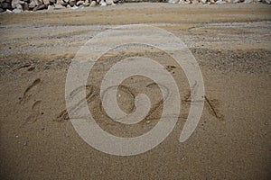 New Year 2024, lettering on the beach with wave and clear blue sea