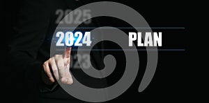 New year 2024 with plans. Businessman pointing to the numbers of the year to set goals and making plans for the coming year