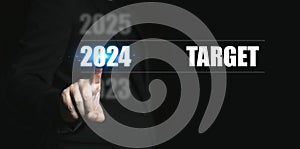 New year 2024 with target. Businessman pointing to the numbers of the year to set target for the coming year
