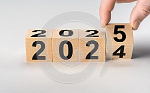New year 2025. 2024 change to 2025. Hand flip over wooden cube block. New year resolution goal concept