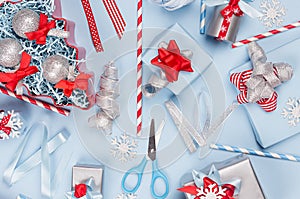 New Year background - bright blue, red and silver metallic gift boxes with ribbons, snowflakes, bows, christmas tree, straws.