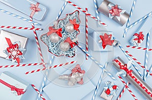 New Year background - bright blue, red and silver metallic gift boxes, straws and christmas tree with ribbons, snowflakes.