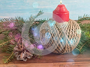 New Year background from a candle surrounded by fir cones