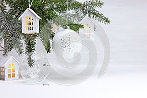 New year background with christmas tree branch, wooden decorative toy houses garland and glass balls