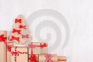 New Year background - handmade christmas tree and gift boxes of kraft paper and red ribbon on white wood board, copy space.