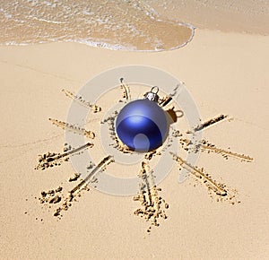 New Year ball in the center of the sun drawn on sand on a beach