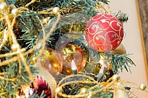 New Year baubles on decorated Christmas Tree with blurred background