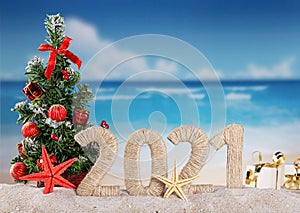 New year on the beach. Christmas tree, inscription 2021 on sunny seaside