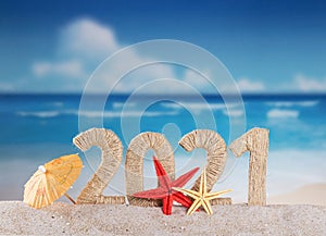 New year on the beach. Inscription 2021 from twine and starfishes in the sand