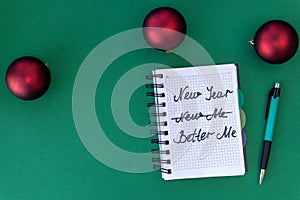 New year, better me. Happy new year quote. Green background with red Christmas balls.Top view