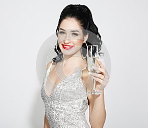 New Year, Birthday, holiday concept: Young attractive woman in evening dress holding glass of champagne
