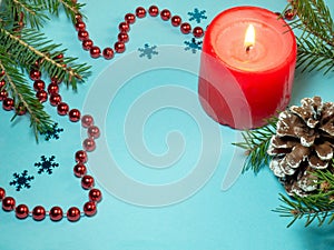 New Year card. Christmas card on blue background. Fir branches. Decorations for the holiday. Red beads, candle and fir cones