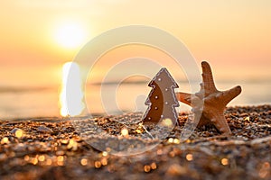 New Year card. Cookies in the shape of a Christmas tree and a starfish with a garland on the background of the sunset and the sea.