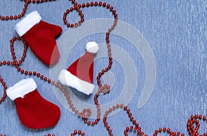 New Year, Christmas background flat lay. Stitched holiday toys, sock, mittens, hat and decorative garland of red on a blue surface