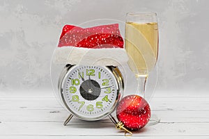 New Year or Christmas card - an alarm clock in a Santa Claus hat and wine. New Year and Christmas concept