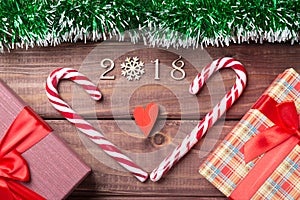 New Year or Christmas card. 2018 wooden decorative figures with heart shaped candy canes, giftboxes and red heart with green spang