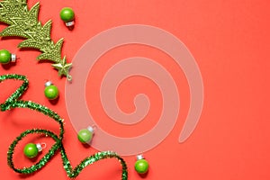 New Year or Christmas composition 2021. Top view xmas decorative red paper background with green tinsel and Christmas decorations